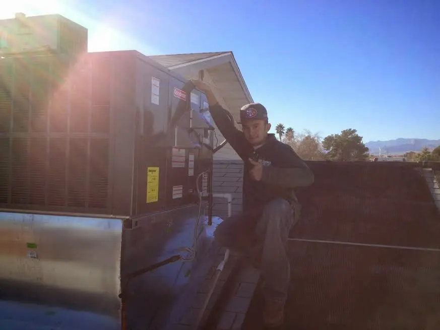 HVAC technician performing AC Tune-Up on a rooftop unit in Palmetto Estates